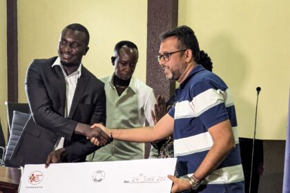 Kisumu RFC Chairman Dr. Gabriel Ouma receives and displays a dummy cheque of KSh 2 million from Homeland Itoya Events Ltd during the sponsorship unveiling ceremony. Photo/Jandiko