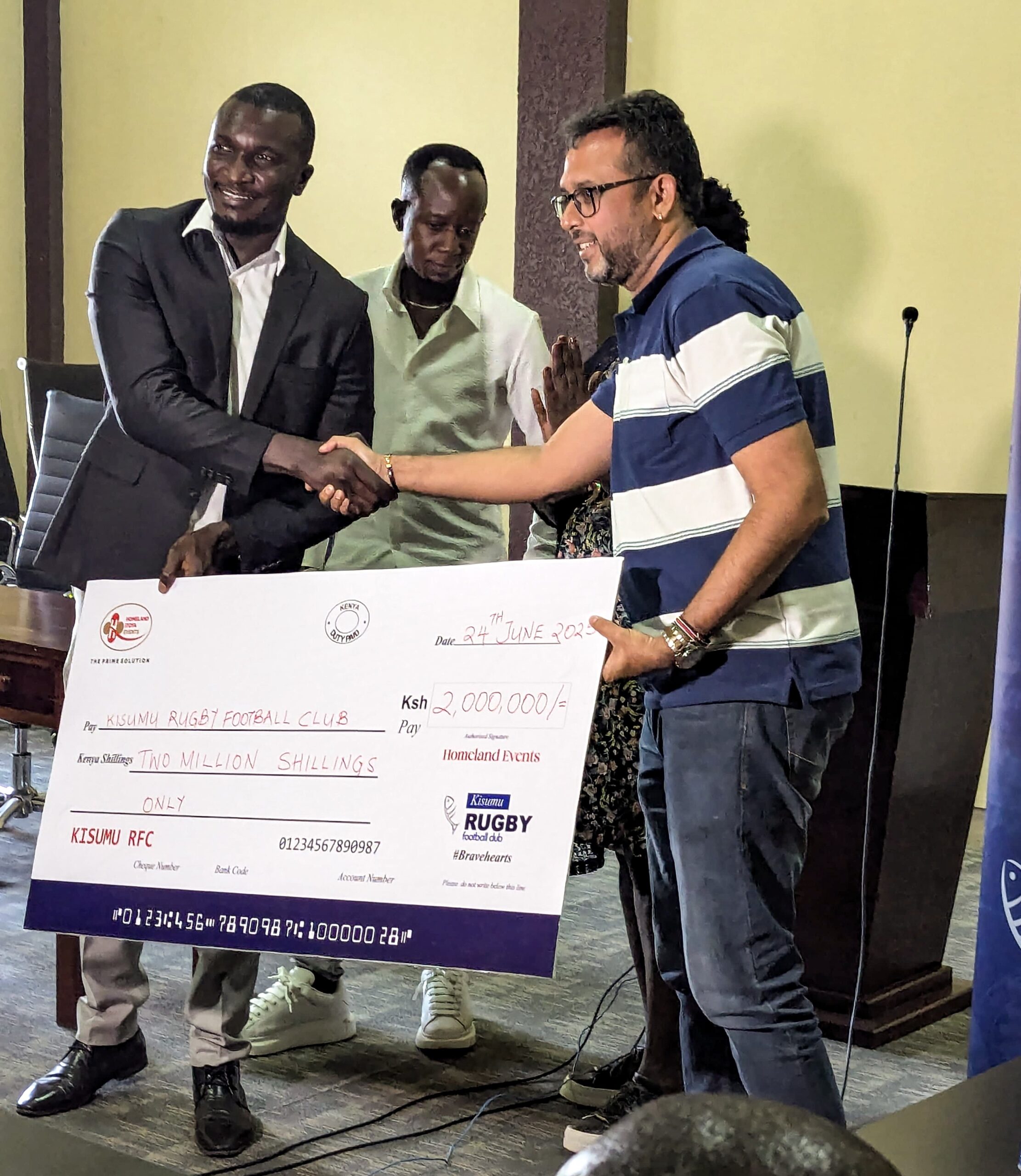 Kisumu RFC Chairman Dr. Gabriel Ouma receives and displays a dummy cheque of KSh 2 million from Homeland Itoya Events Ltd during the sponsorship unveiling ceremony. Photo/Jandiko